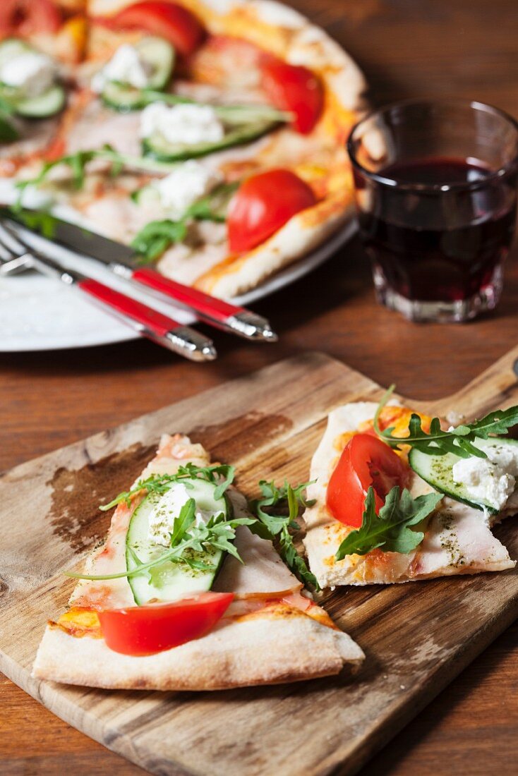Pizza with tomato, cucumber, rocket and cream cheese
