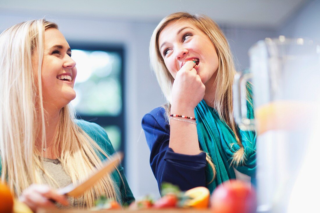 Young women preparing fruit drink