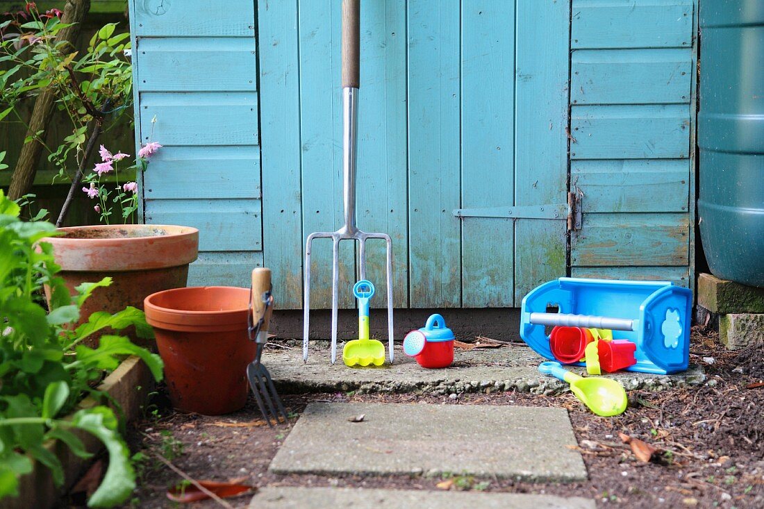 Gardening tools, pots and toys outside shed