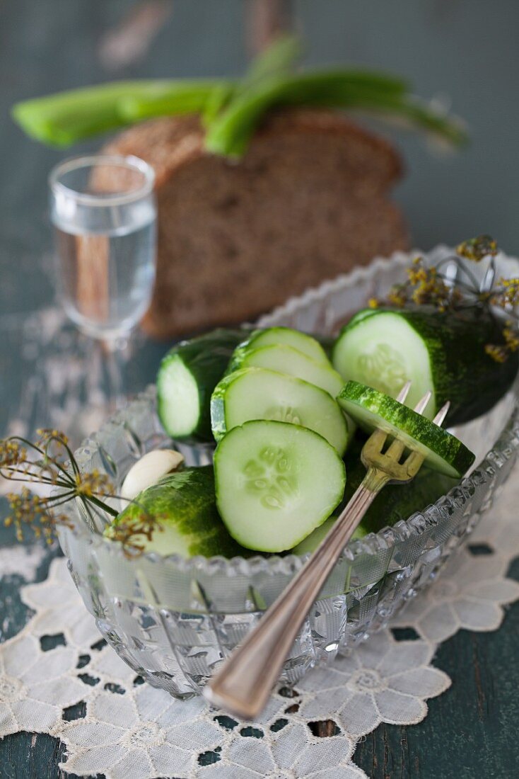 Salzgurken in Kristallschale mit Brot und Wodka