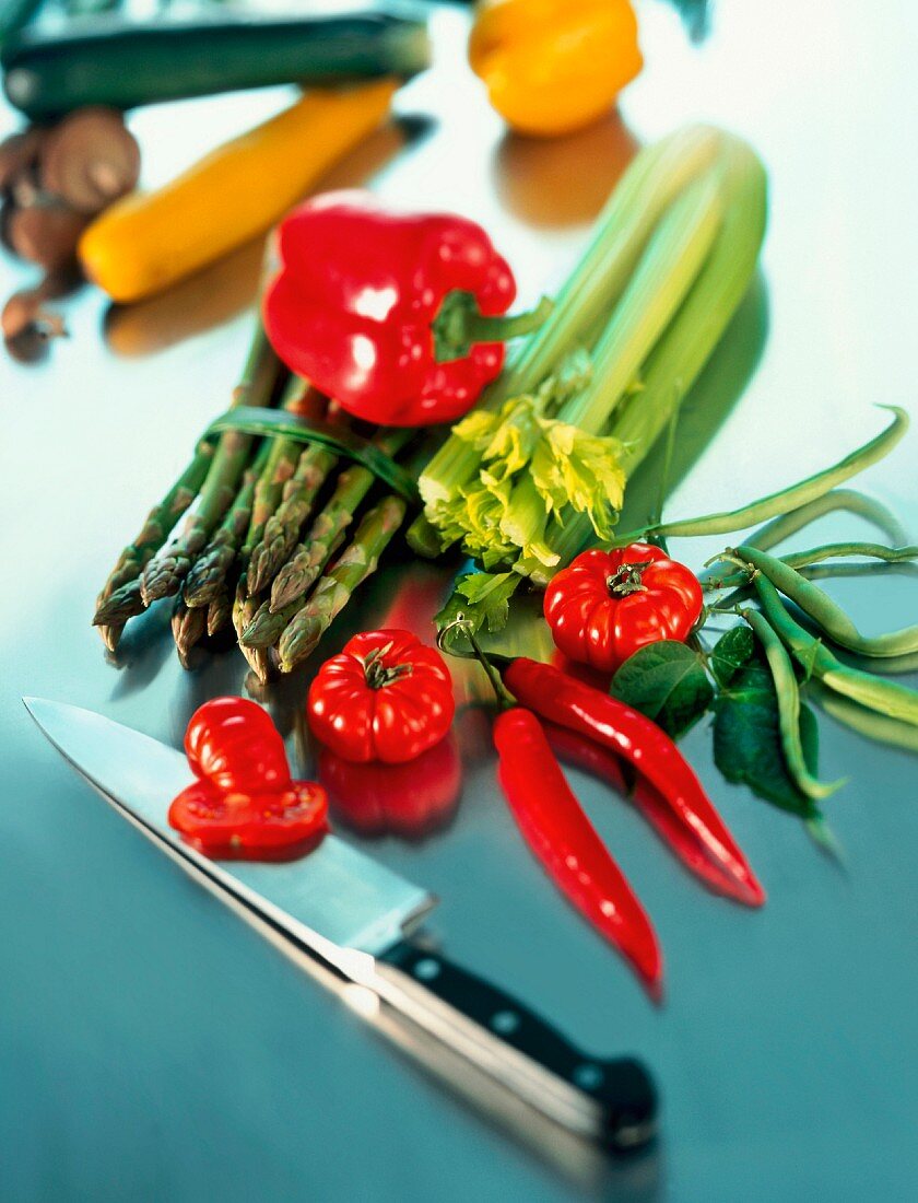 A still life of vegetables, featuring asparagus, celery, tomatoes, chillies, beans and a pepper