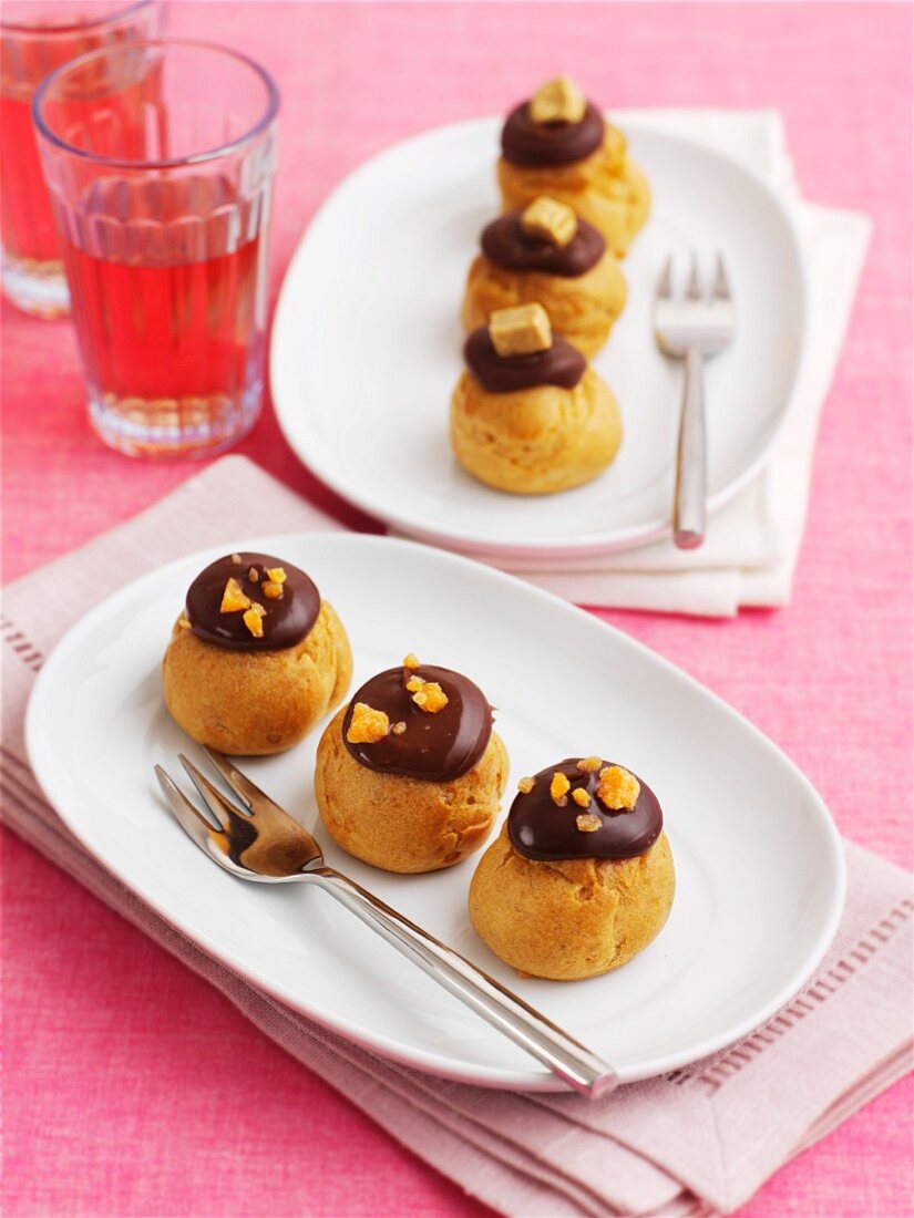 Profiteroles with chocolate topping on a pink cloth