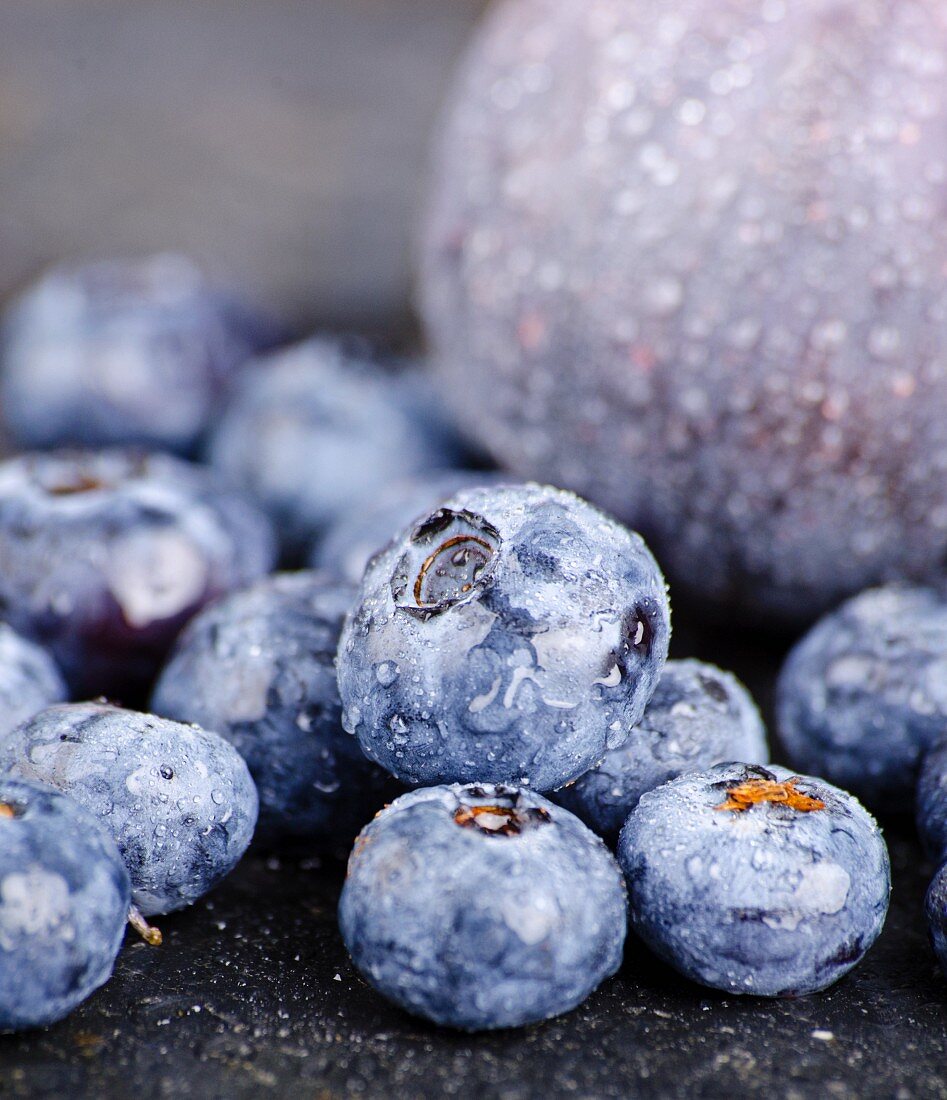 Blueberries with water droplets in front of a fig