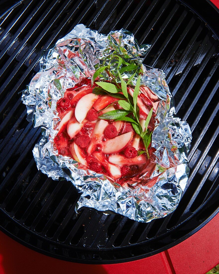 Red fruits in aluminium foil on the barbecue grill