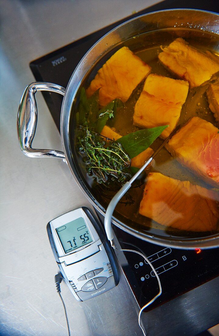 Salmon in olive oil with a thermometer