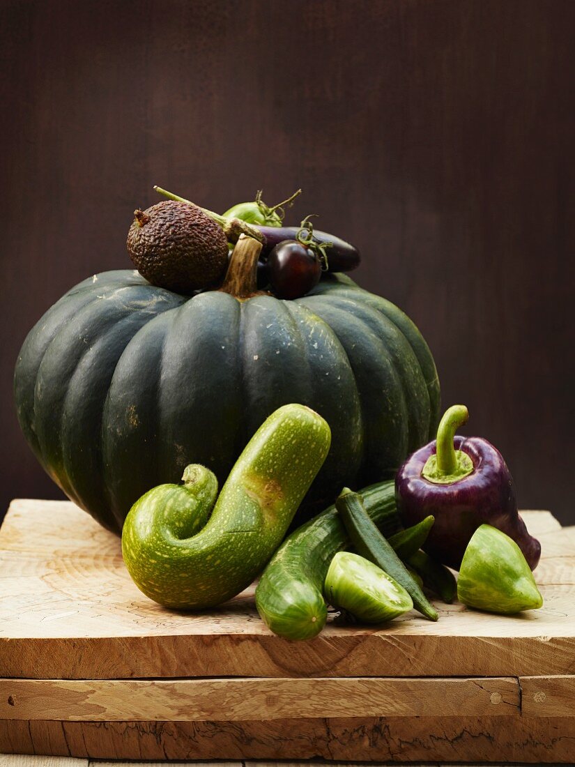 A still life of green vegetables, with squash, courgette, okra, cucumber and a pepper