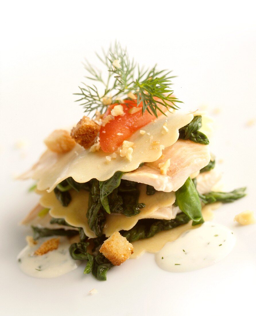 Pasta layered with trout fillet, spinach and croutons