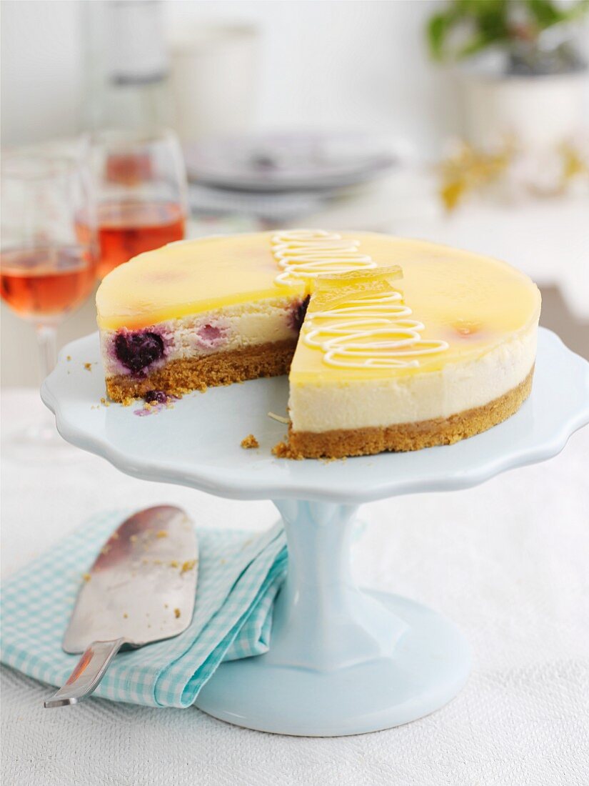 Lemon and blueberry cheesecake on a cake stand, slices removed