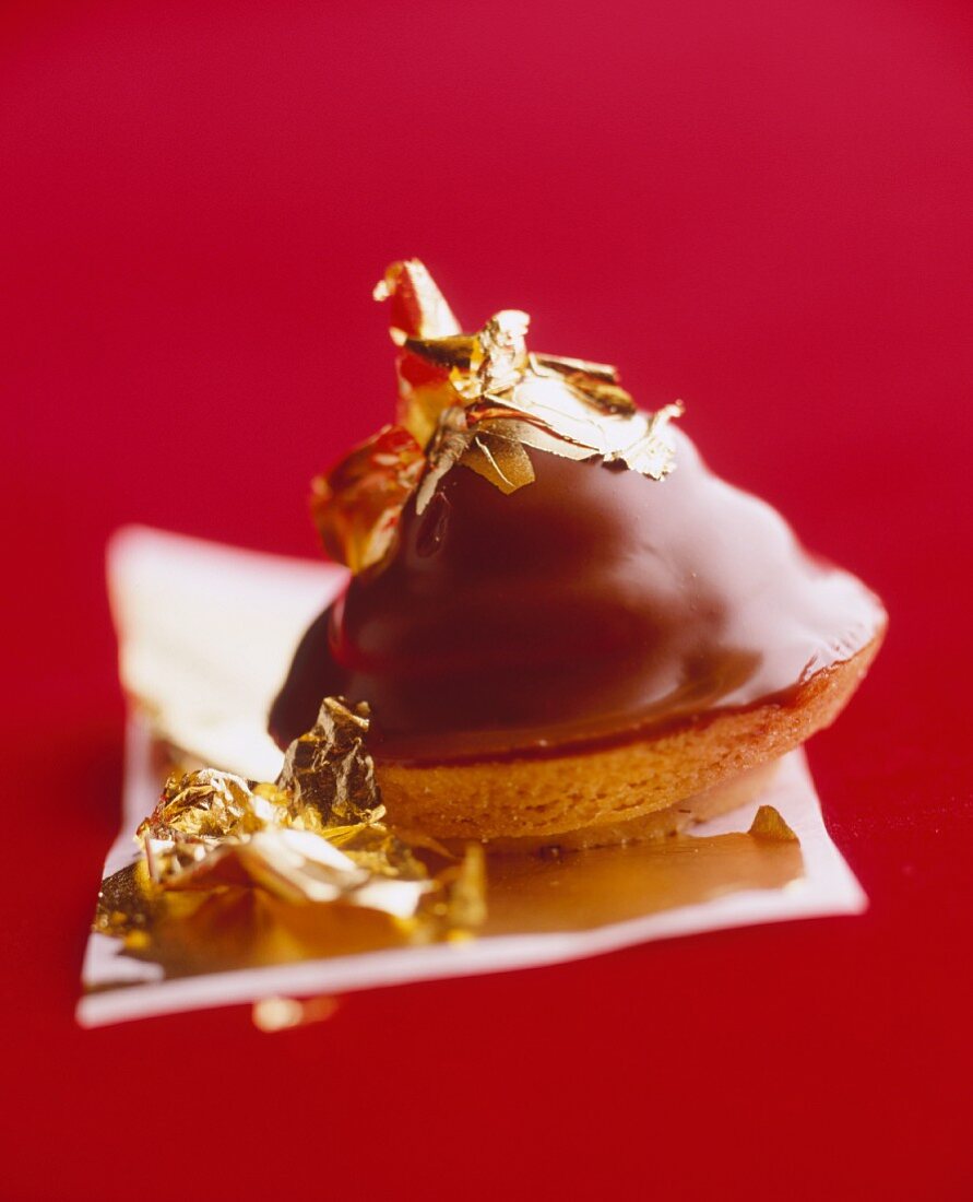 A pastry topped with chocolate and gold leaf