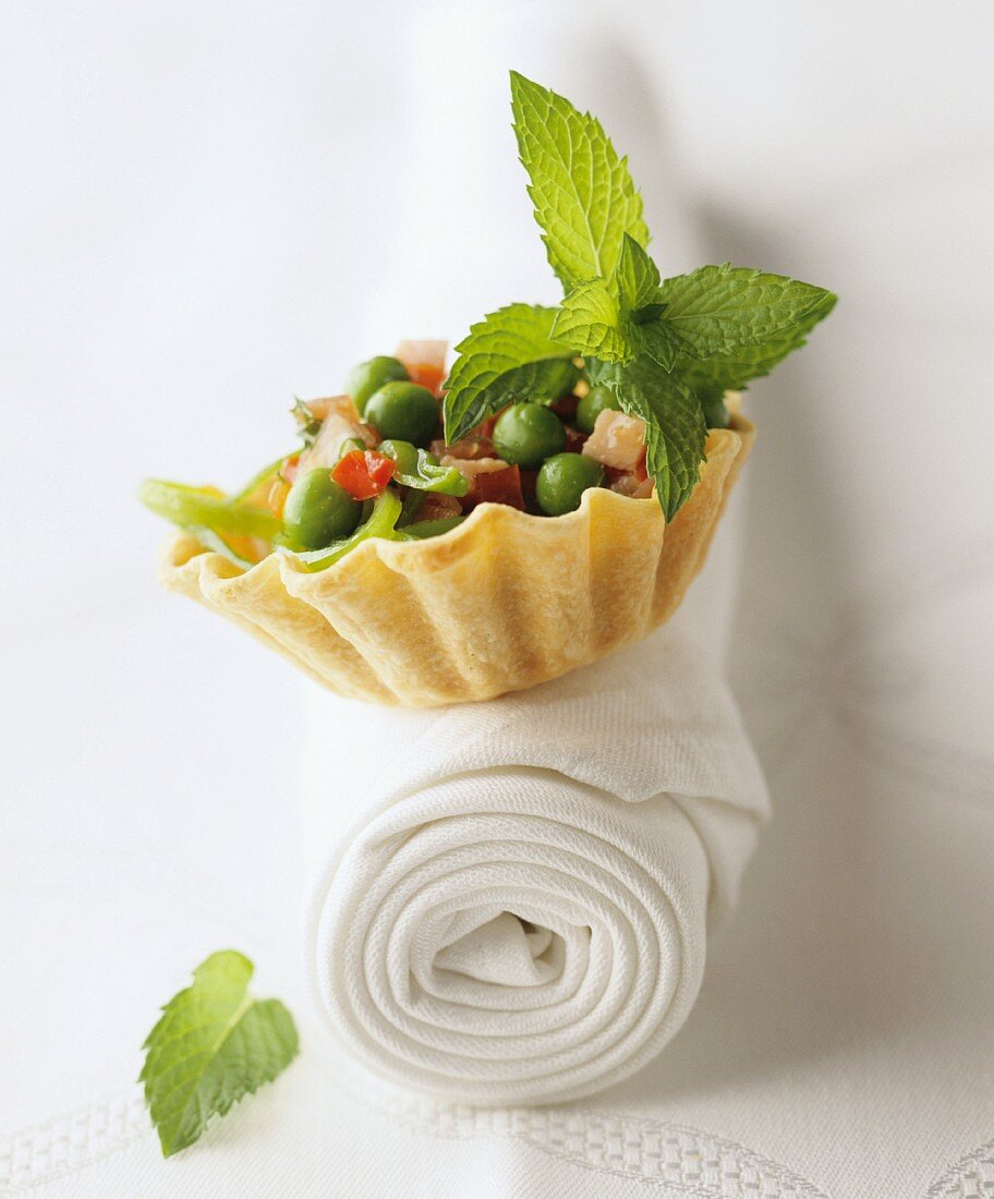 A pastry case filled with vegetables and mint