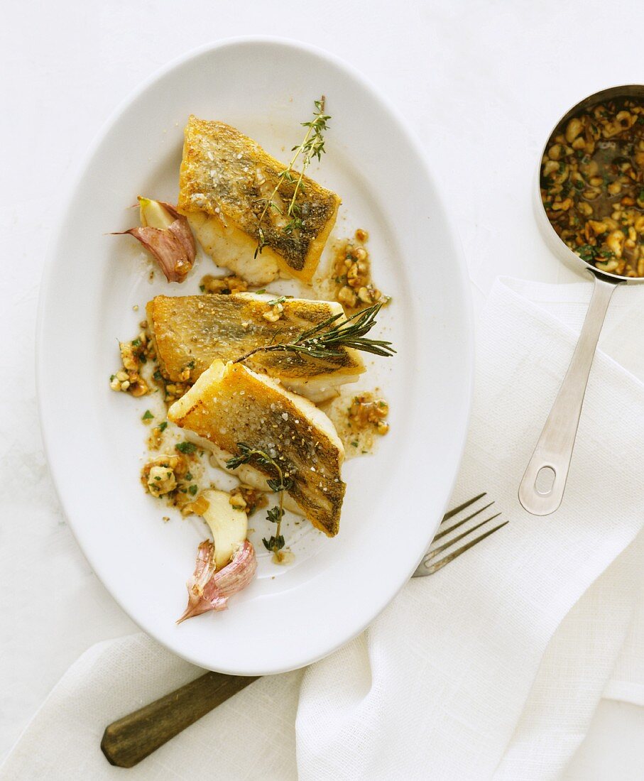 Fried fish fillets with garlic, thyme and rosemary