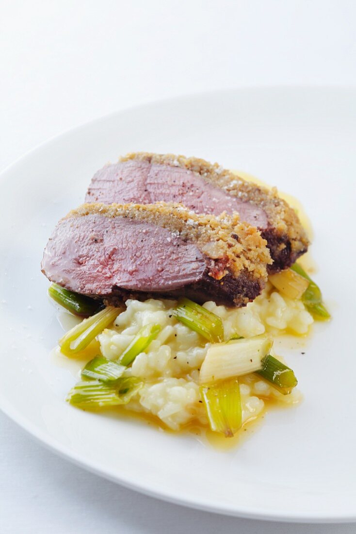 Duck breast with chestnut crust on spring onion risotto