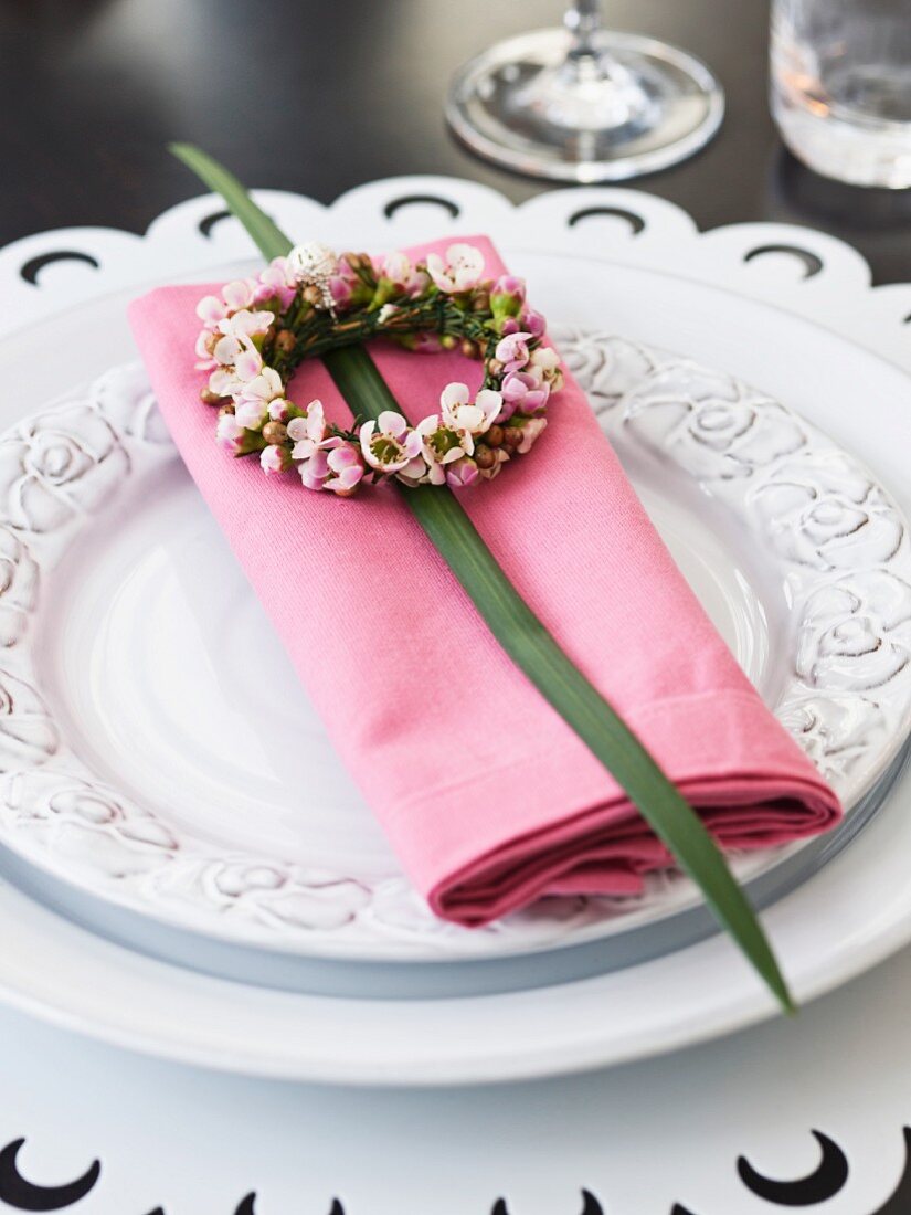 Elegantes Gedeck mit Serviette und Blumenkränzchen