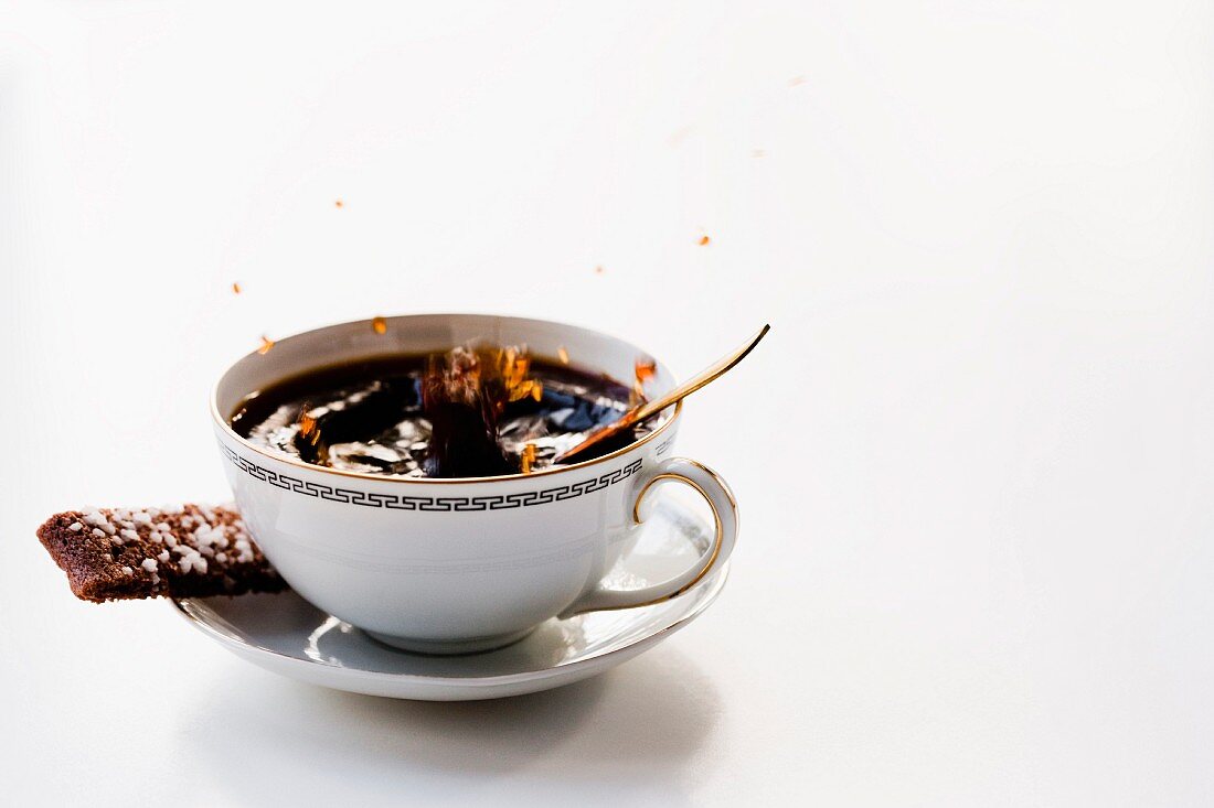 Schwarzer Kaffee spritzt aus der Tasse
