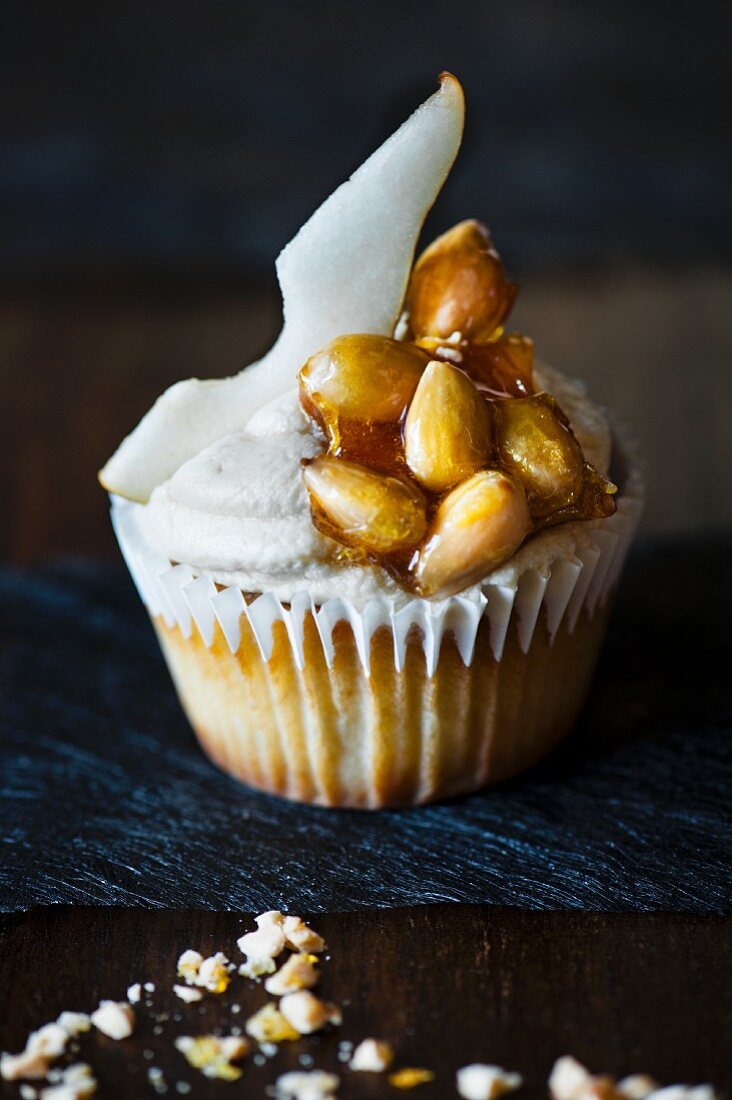 Cupcake mit Birnenscheibe der Birne und karamellisierten Mandeln