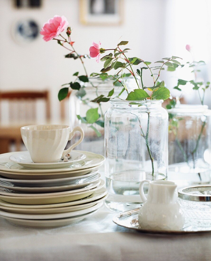 Geschirr & Glasgefässe als Vasen auf Tisch