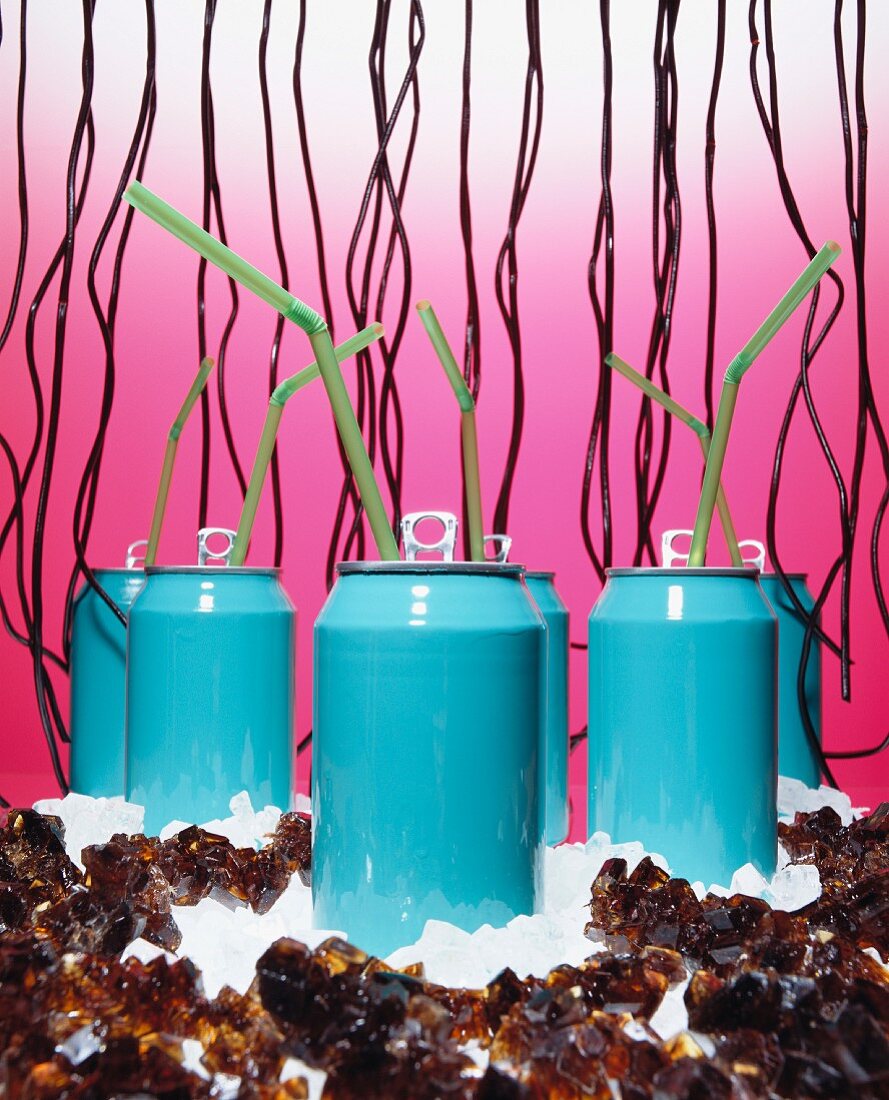 Drinks cans surrounded by rock sugar, sugar and liquorice bootlaces