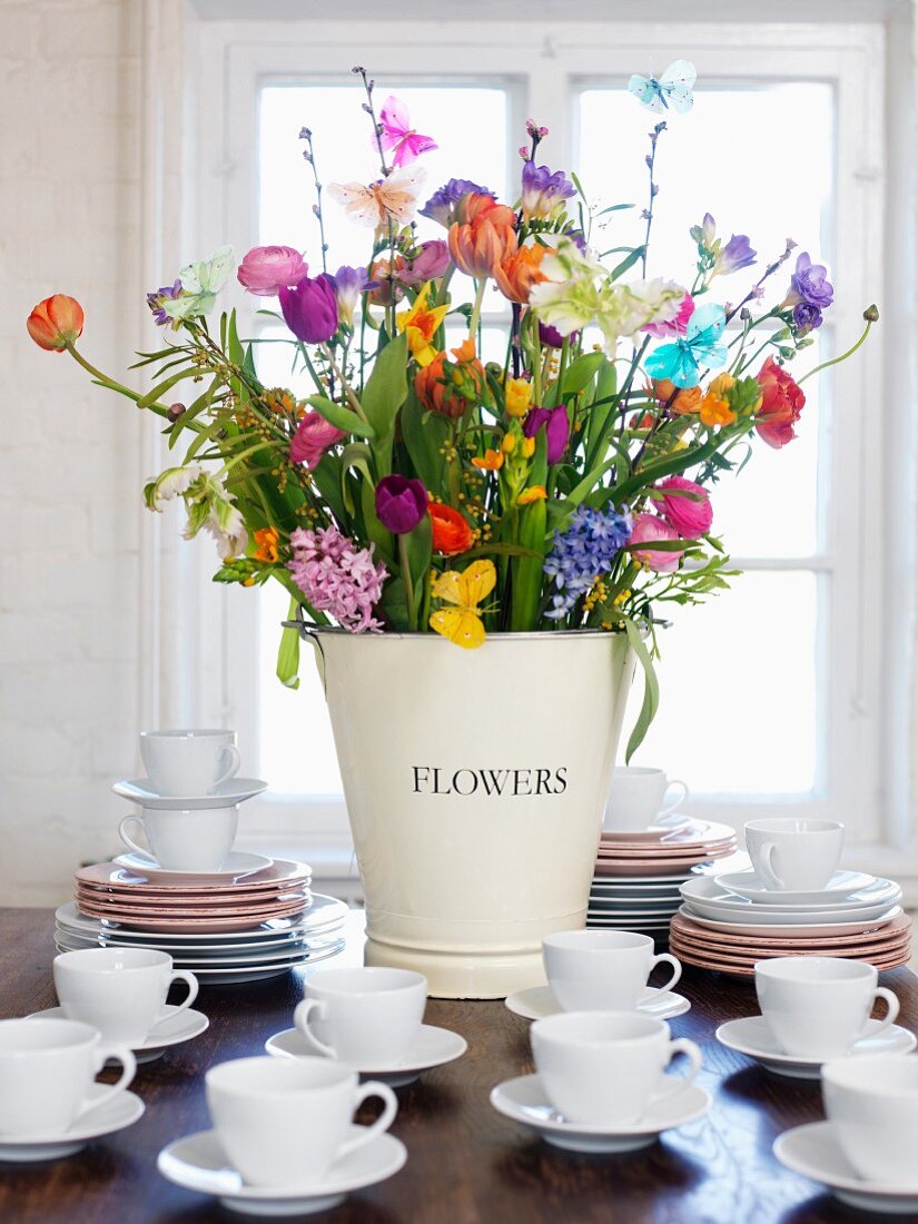 Bouquet and stack of cups and saucer on table , close-up