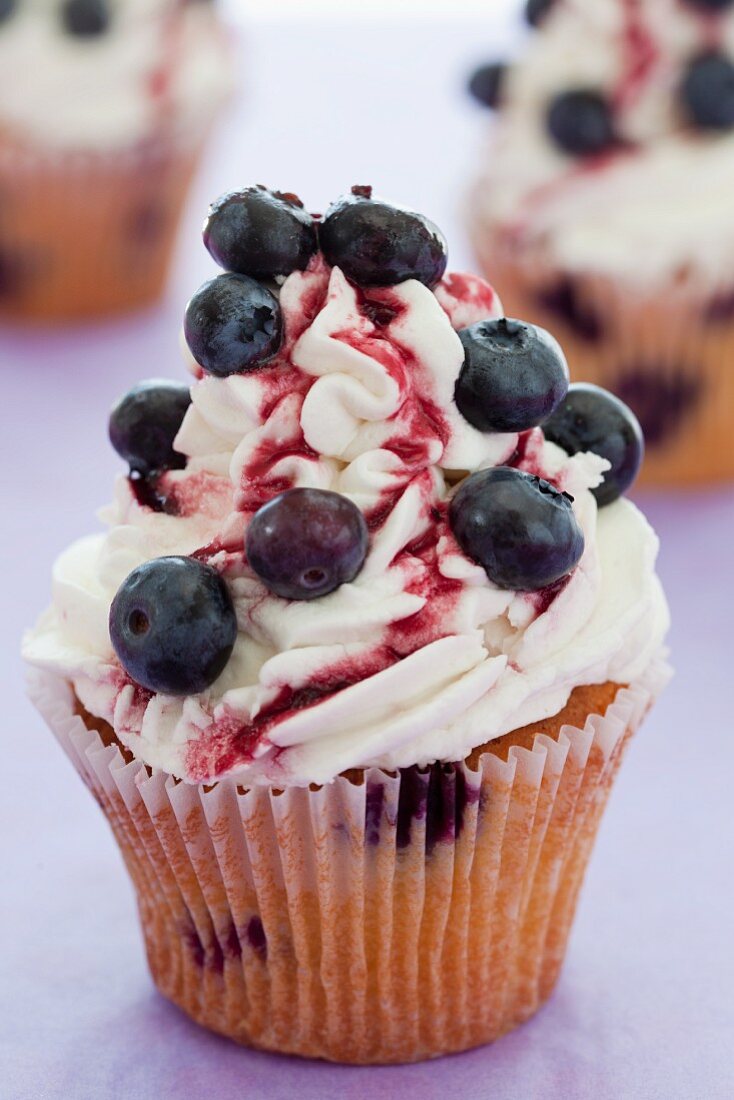 Blueberry cupcakes with mascarpone icing and cherry sauce