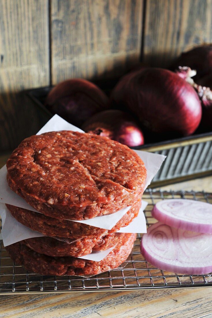 Raw burgers and sliced onions