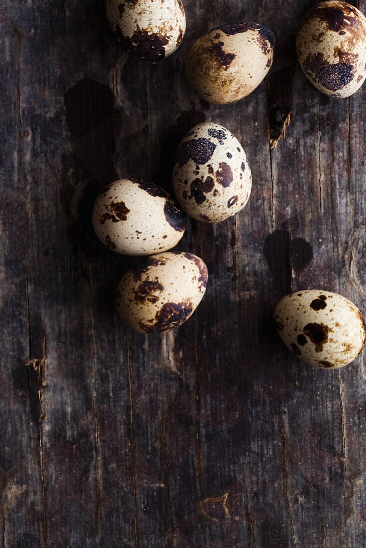 Several quail's eggs on a wooden surface