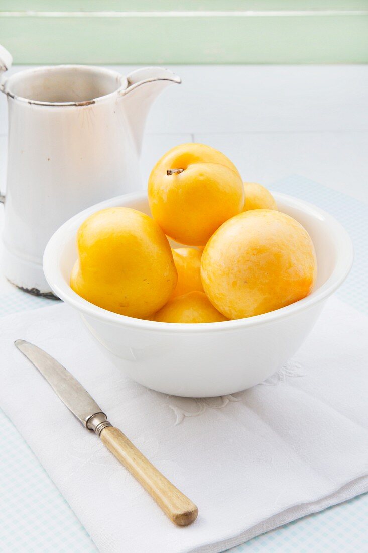 Yellow plums in a white bowl