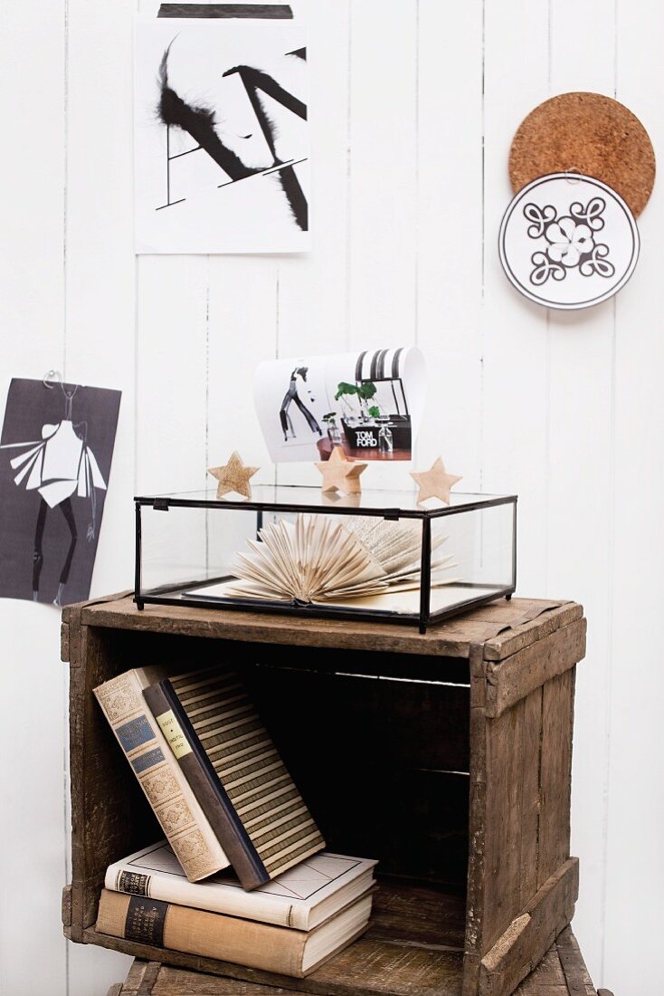 Books in stacked, vintage wooden crates and black and white decor on vertical wooden cladding