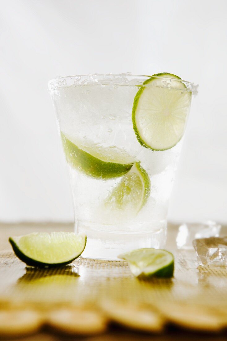 Cocktail with vodka and lime wedges