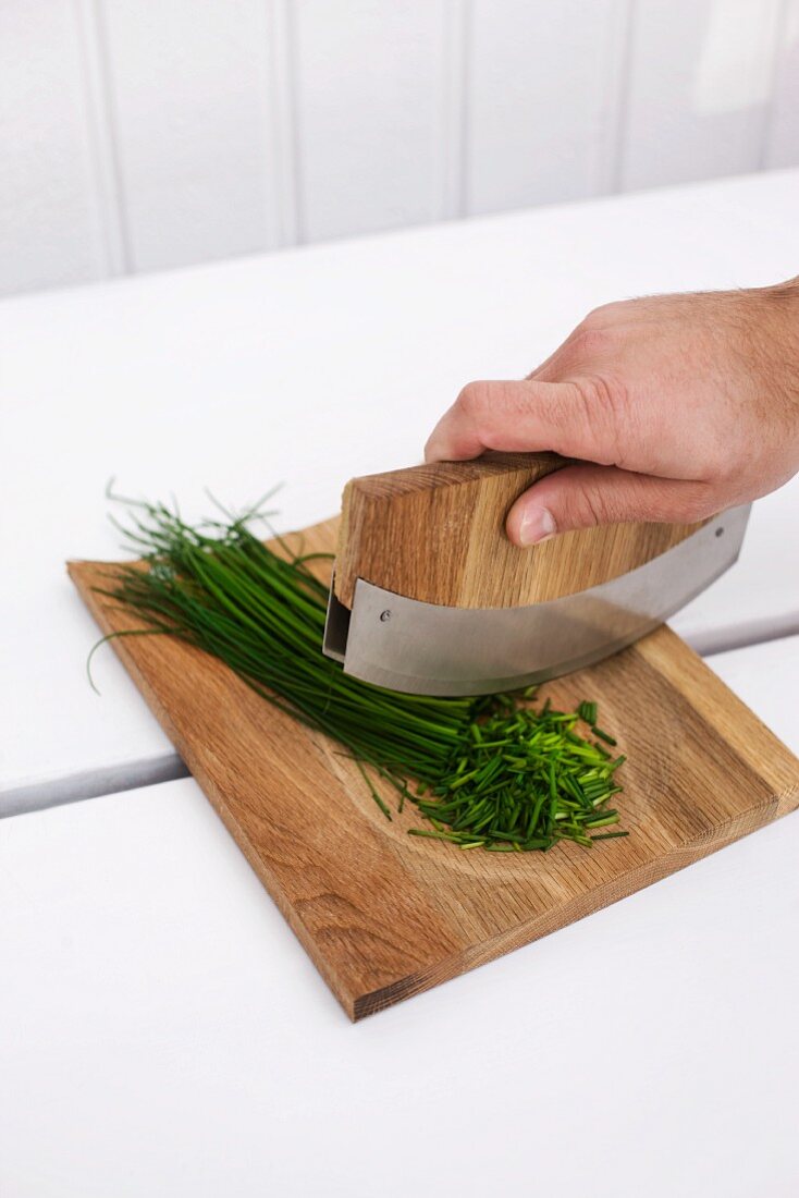 Chives being chopped with mezzaluna knife