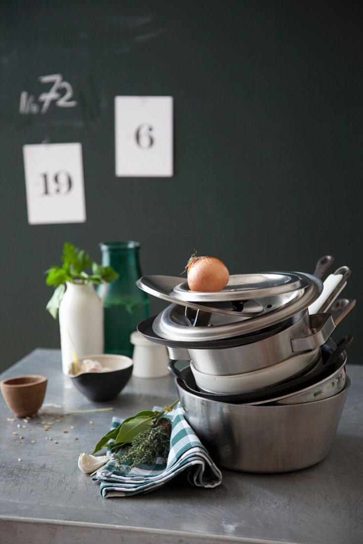 A stack of stainless steel pots on a metal table