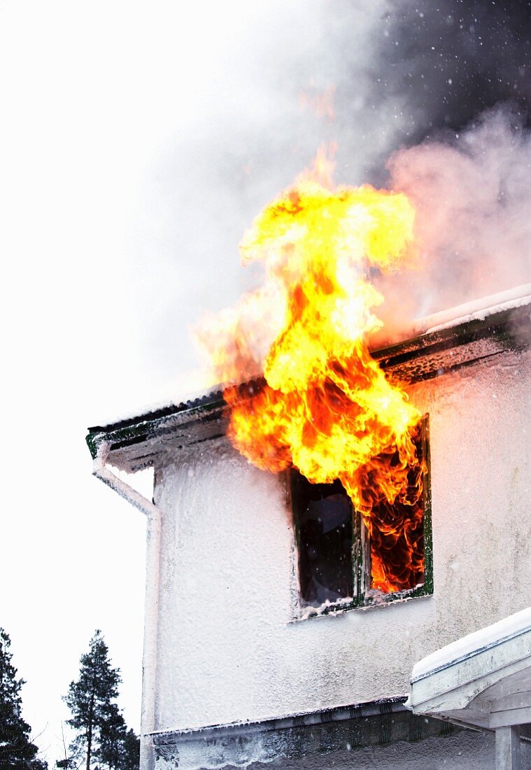 Blazing fire licking out of house window