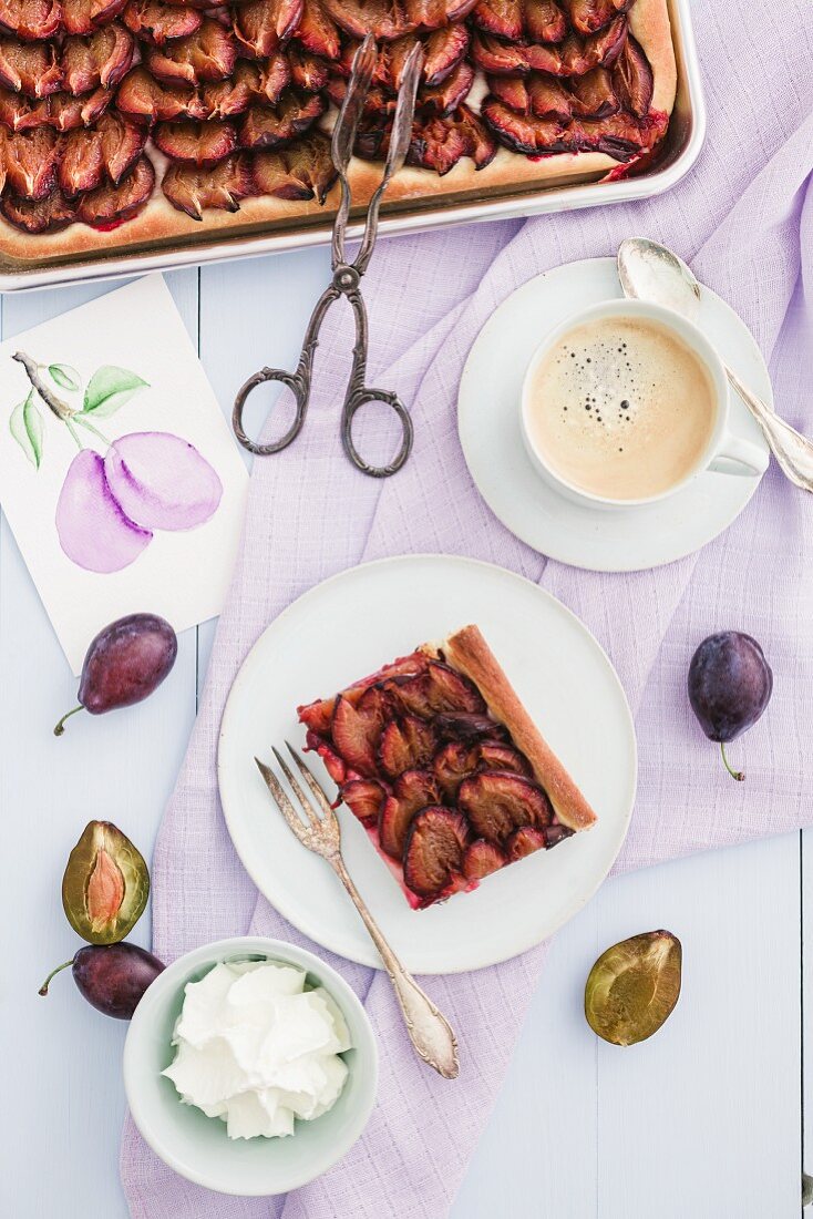 Plum cake with cream and coffee, and a picture of plums