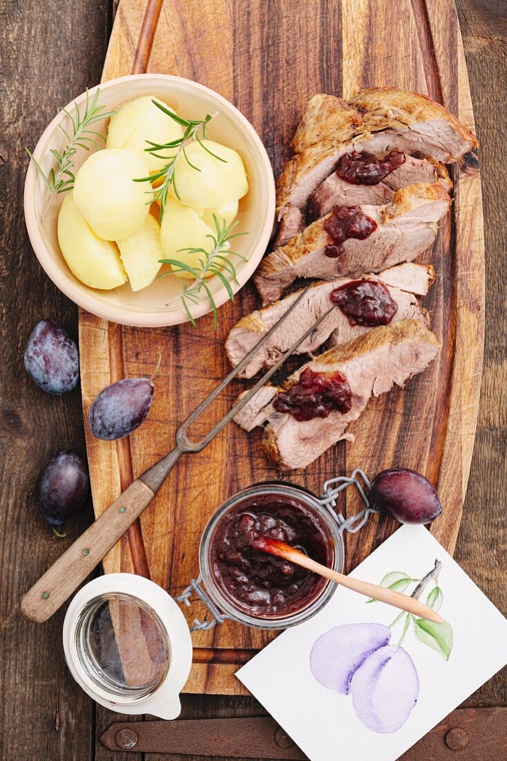 Roast pork, cut into slices, with plum chutney and boiled potatoes