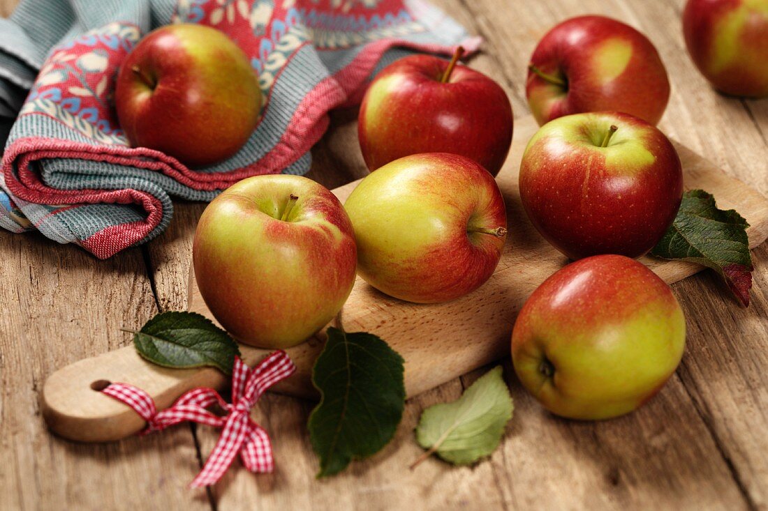 Several Braeburn apples on a chopping board