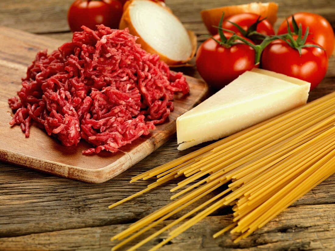 Zutaten für Spaghetti Bolognese: Hackfleisch, Spaghetti, Parmesan, Tomaten, Zwiebeln