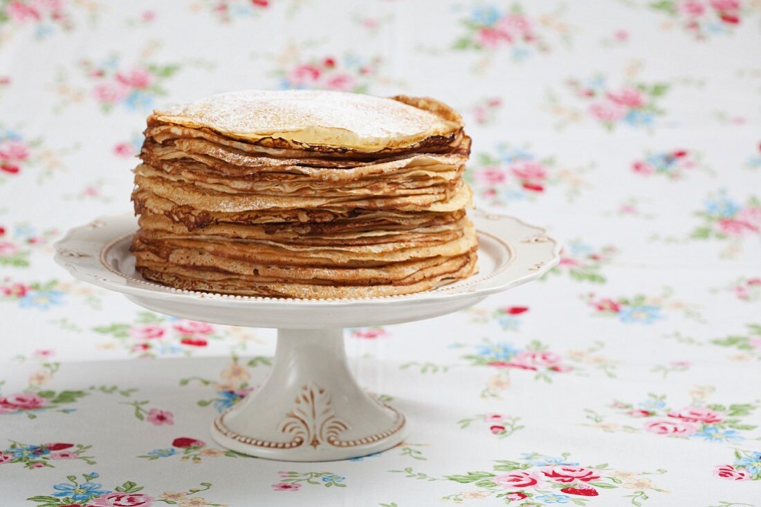 A stack of pancakes on a cake stand