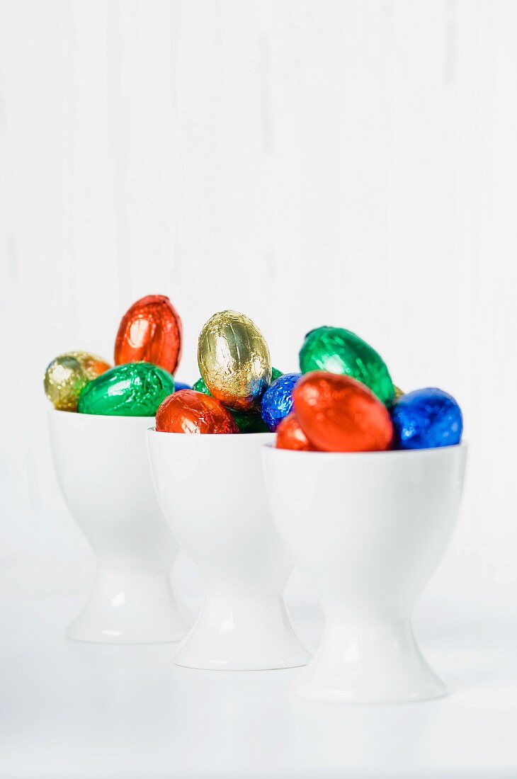 Colourful chocolate eggs in eggcups