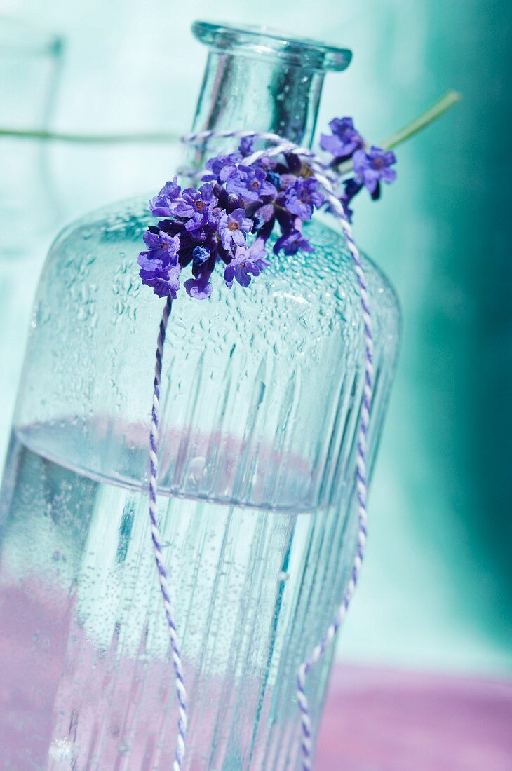 A bottle of scented oil and a sprig of lavender