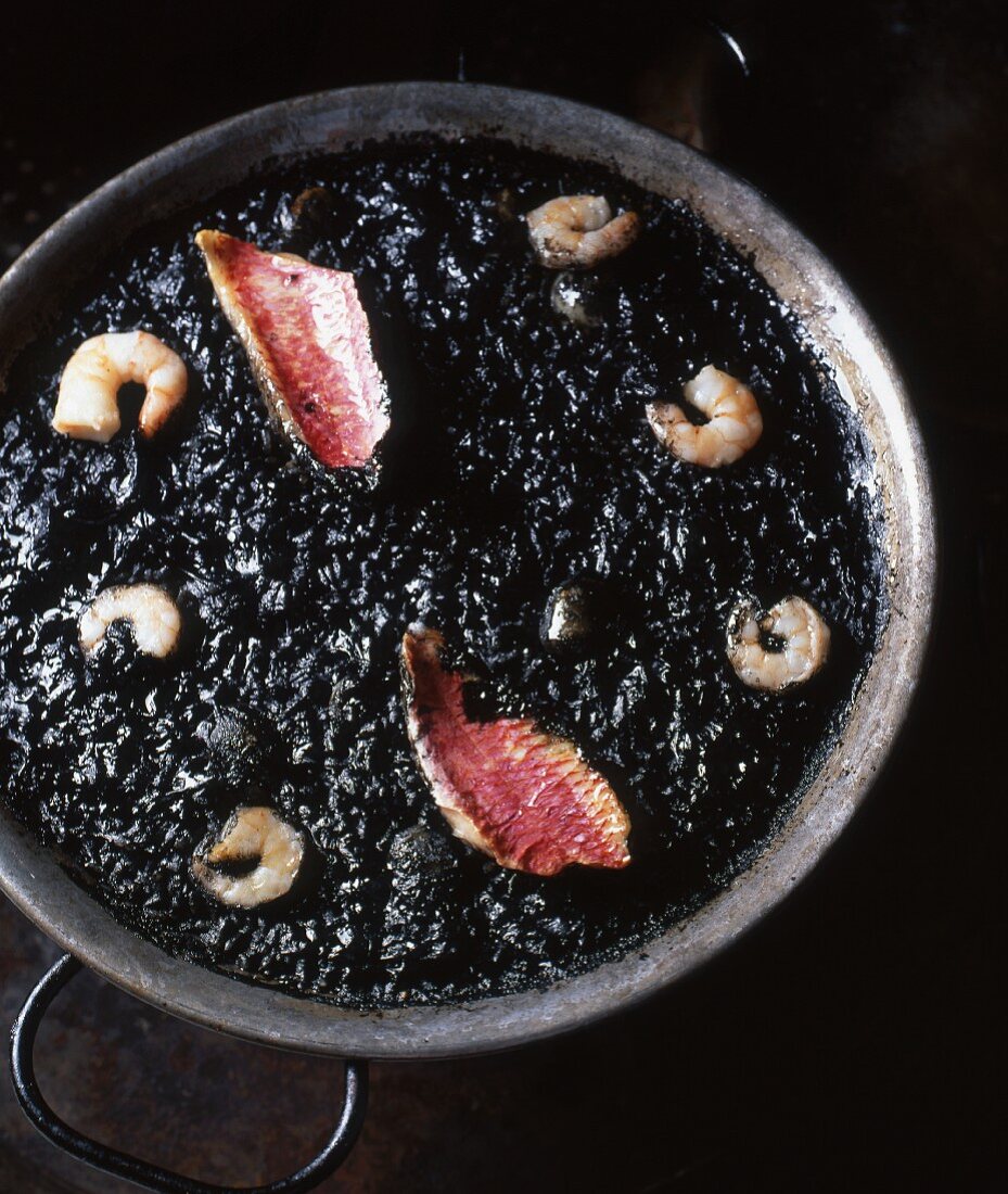 Squid ink rice with red mullet and prawns