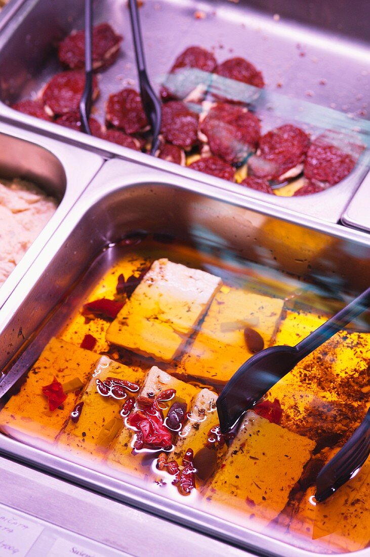 Cheese preserved in oil on display in the counter at a delicatessen