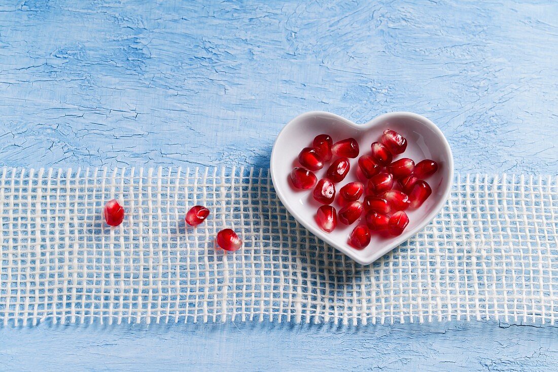 Pomegranate seeds in a heart-shaped bowl