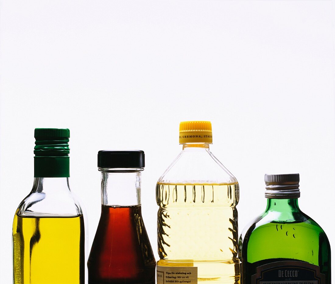Vier verschiedene Öle in Flaschen (Ausschnitt)