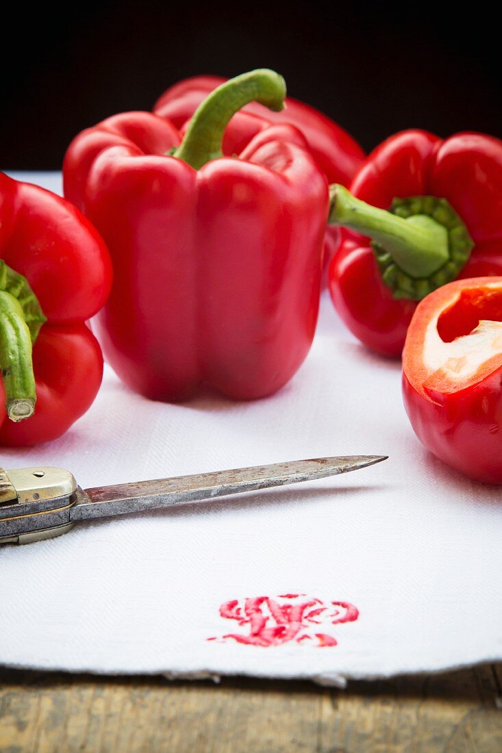 Red peppers on a tea towel with a knife