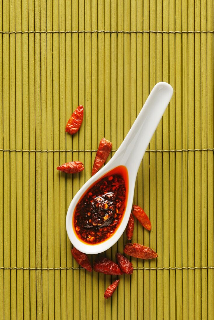 Chilli oil on a spoon, and dried chillies (view from above)
