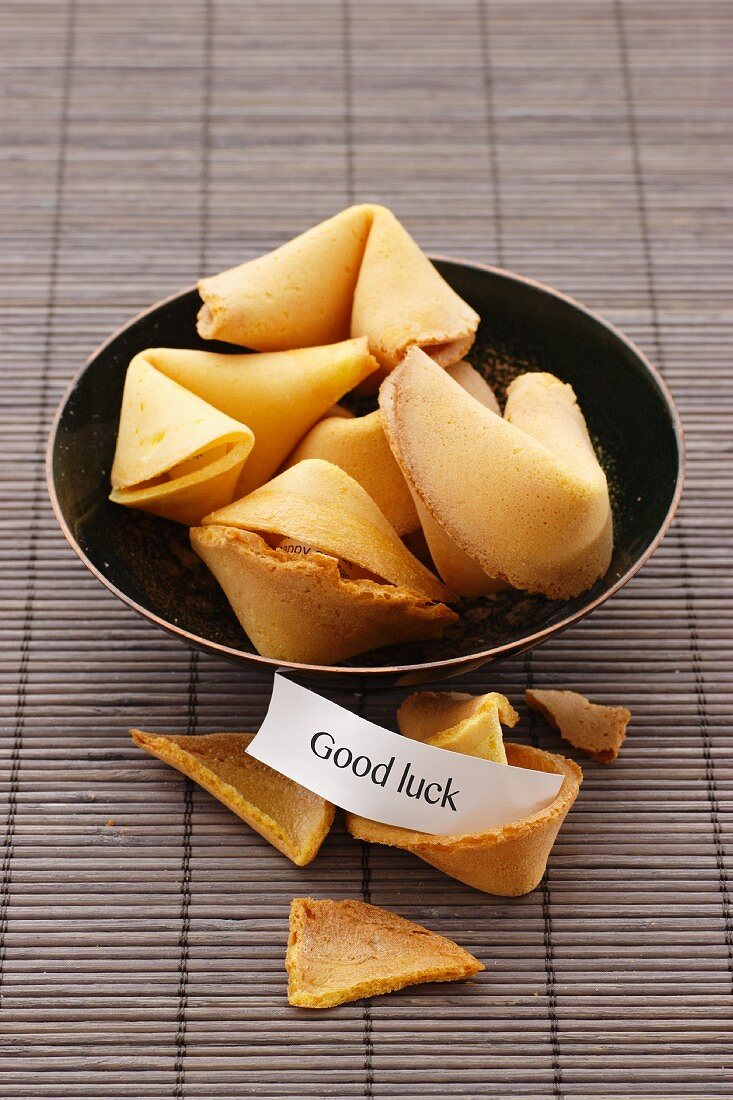 Fortune cookies in a bowl on a bamboo mat