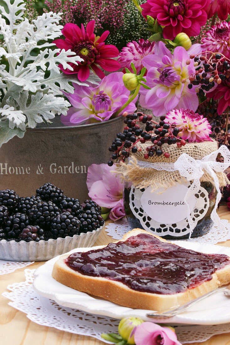 Toast with blackberry jam in front of a bouquet of summer flowers