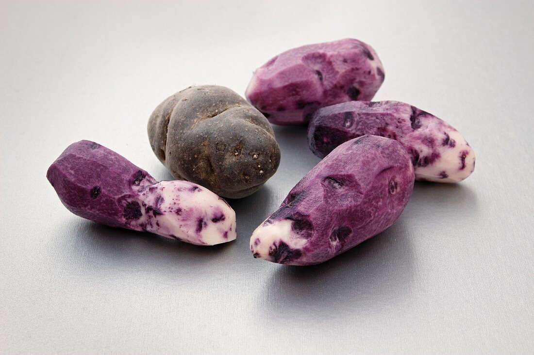 Purple Vitelotte potatoes, peeled and unpeeled