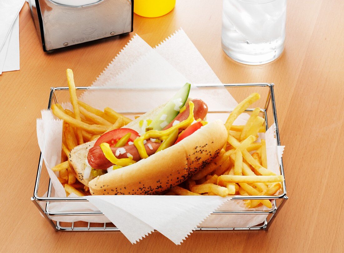 A Hot Dog with the Works and French Fries in a Metal Basket