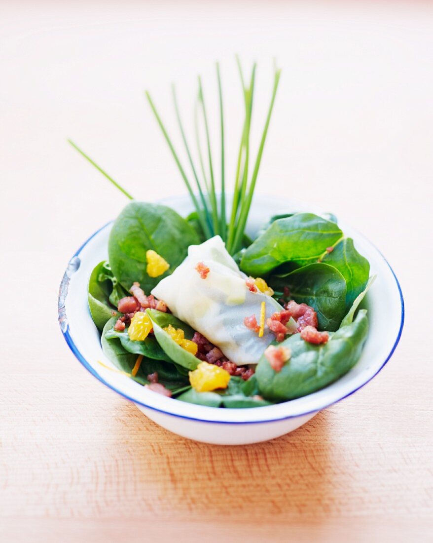Rice paper rolls filled with avocado on a bed of spinach
