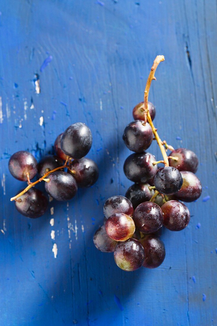 Rote Weintrauben auf blauem Holzbrett